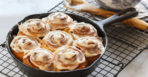 cinnamon rolls dans une poelle sur une grille de refroidissement