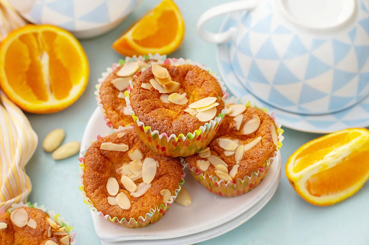 Moelleux à l’orange et aux amandes, doré et saupoudré d’amandes effilées, posé sur une assiette d’hiver