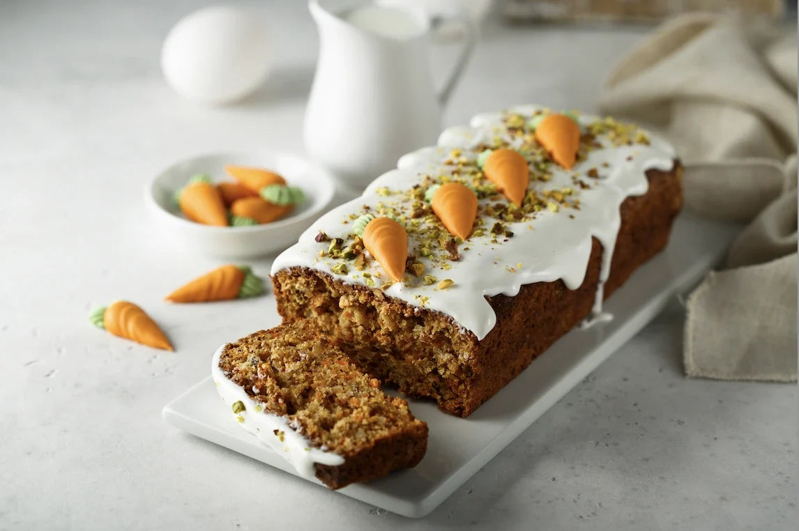Carrot cake moelleux aux noix, recouvert d’un glaçage cream cheese blanc, décoré de noix concassées.