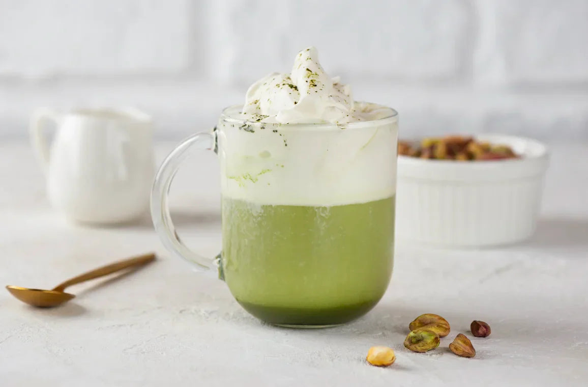 Tasse de matcha latte chaud, mousse verte crémeuse sur le dessus, servie dans une tasse en céramique japonaise.