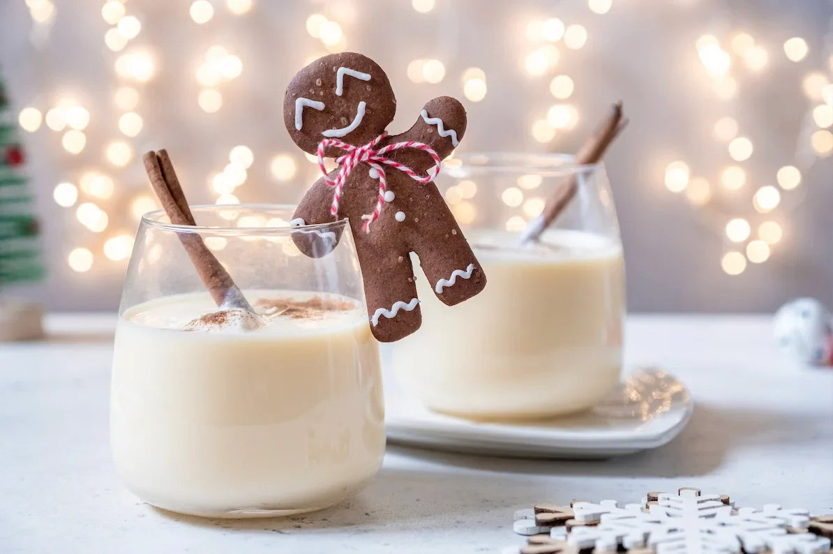 Tasse de lait de Noël chaud, crémeux et saupoudré de cannelle, décorée avec un bâton de cannelle.