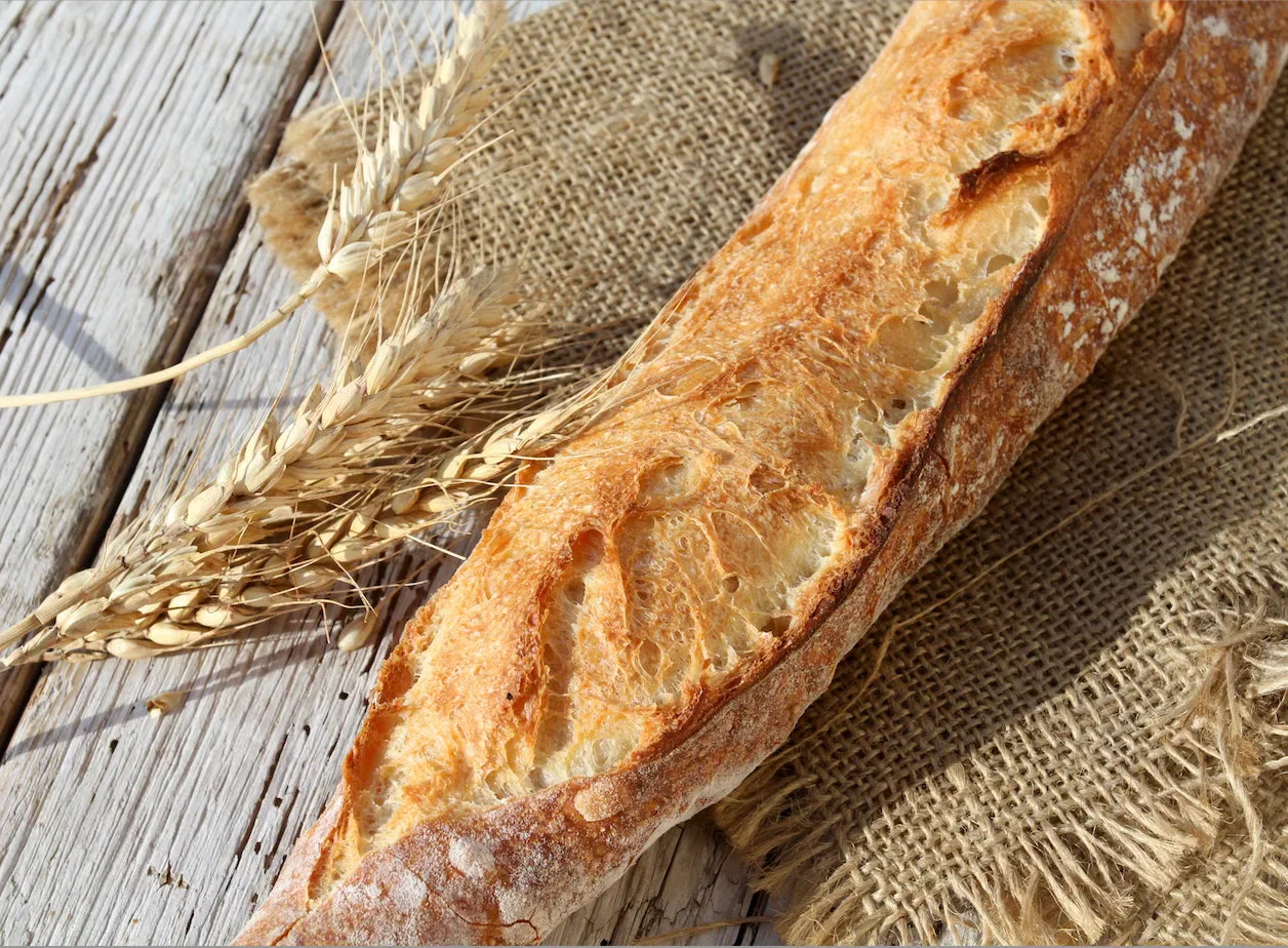 Baguettes françaises dorées et croustillantes, posées sur une grille de refroidissement après cuisson.