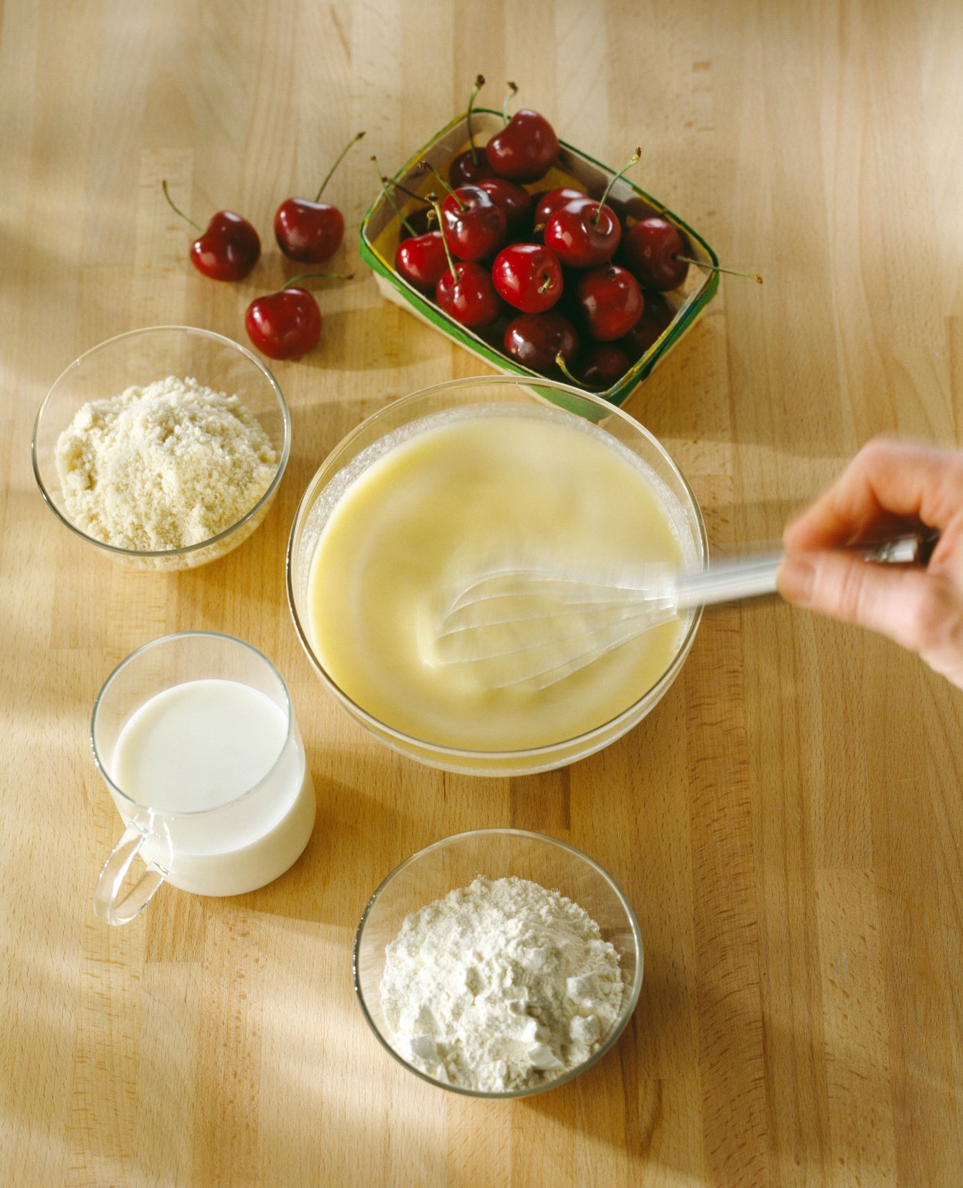 Une carafe en verre débordante de crème anglaise onctueuse, avec une gousse de vanille et des grains de vanille flottant à la surface.