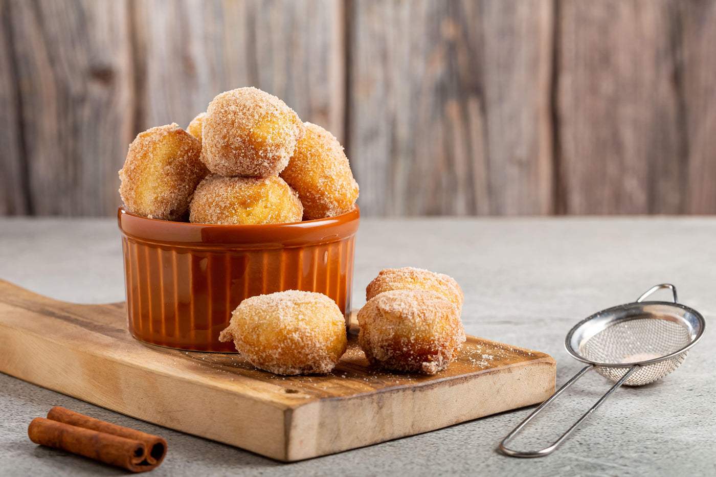 Des beignets aux pommes dorés et croustillants, sortant tout juste de la friture, disposés sur un plat de service.