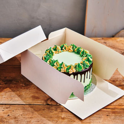 Boîte à gâteau blanche FunCakes ouverte avec gâteau à l’intérieur – côtés pliables