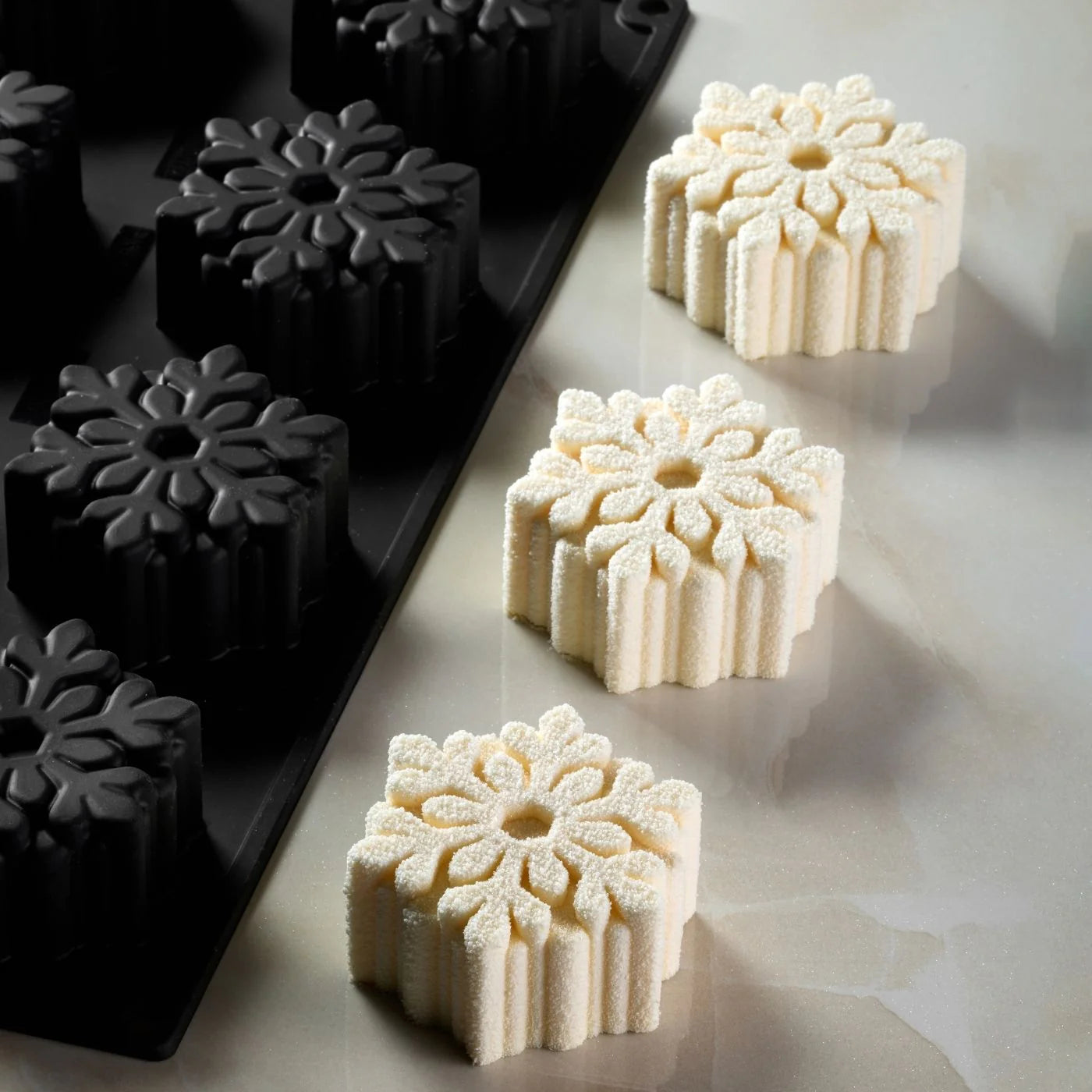 Plaque Pavoflex 400×300 avec 12 empreintes flocon et trois entremets posés.